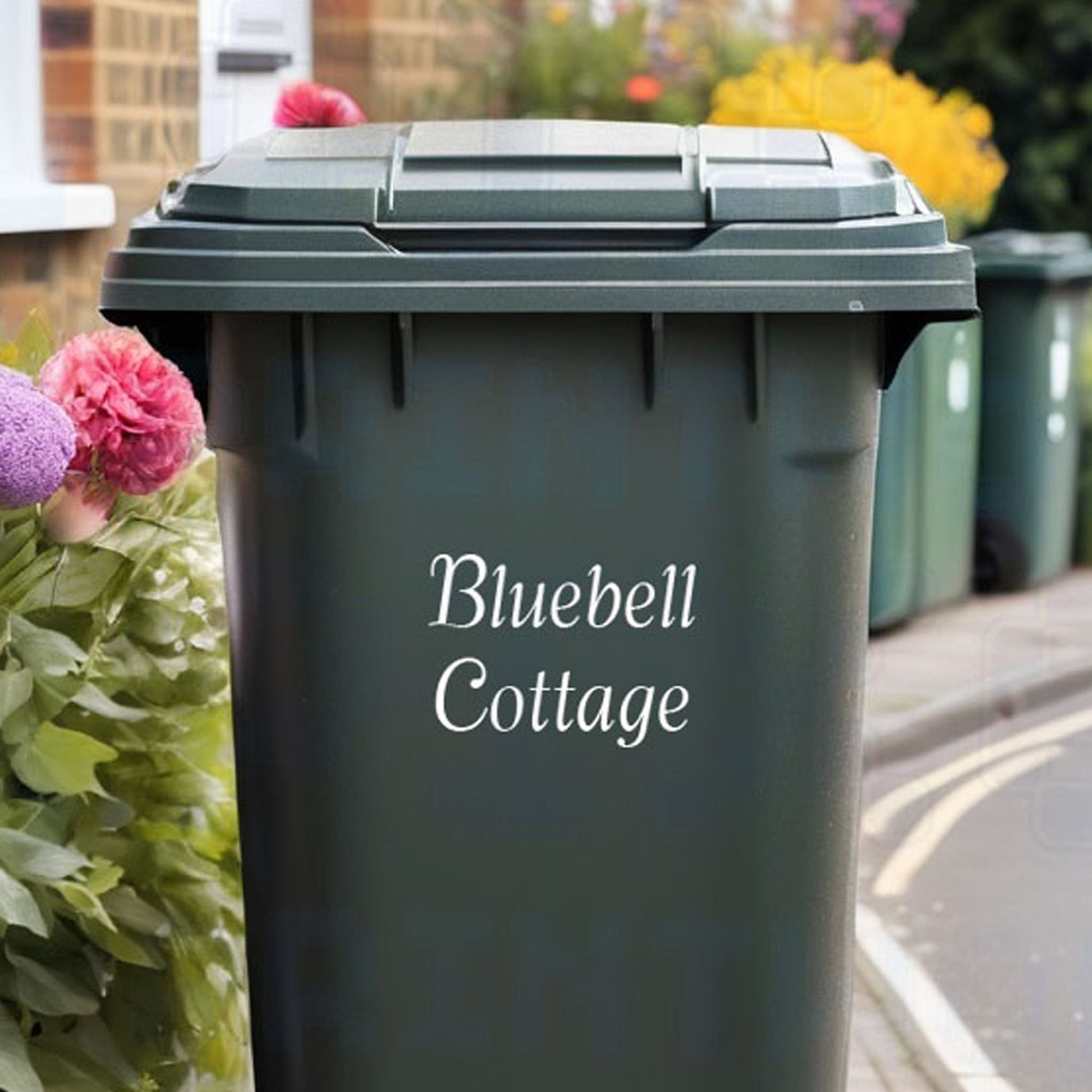 Personalised house name wheelie bin sticker displaying custom property name text on a bin outside a UK home by Pixel Printworks