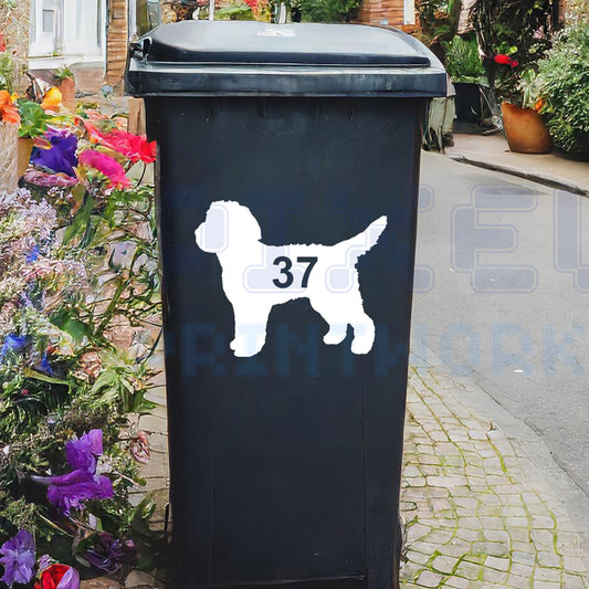 Personalised Cockapoo wheelie bin sticker showing a fluffy Cockapoo silhouette with cut-out house number on a bin outside a UK home by Pixel Printworks