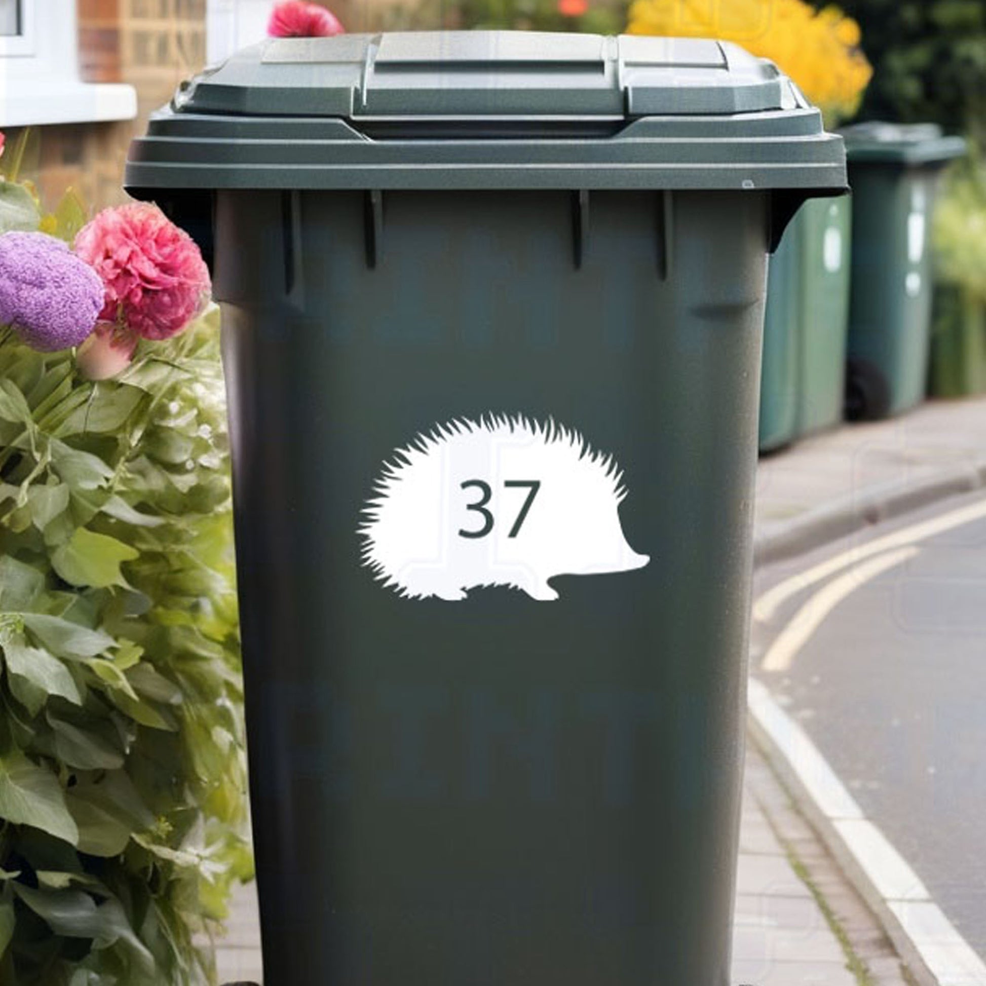 Personalised hedgehog wheelie bin sticker showing cute hedgehog silhouette with cut-out house number on a bin outside a UK home by Pixel Printworks