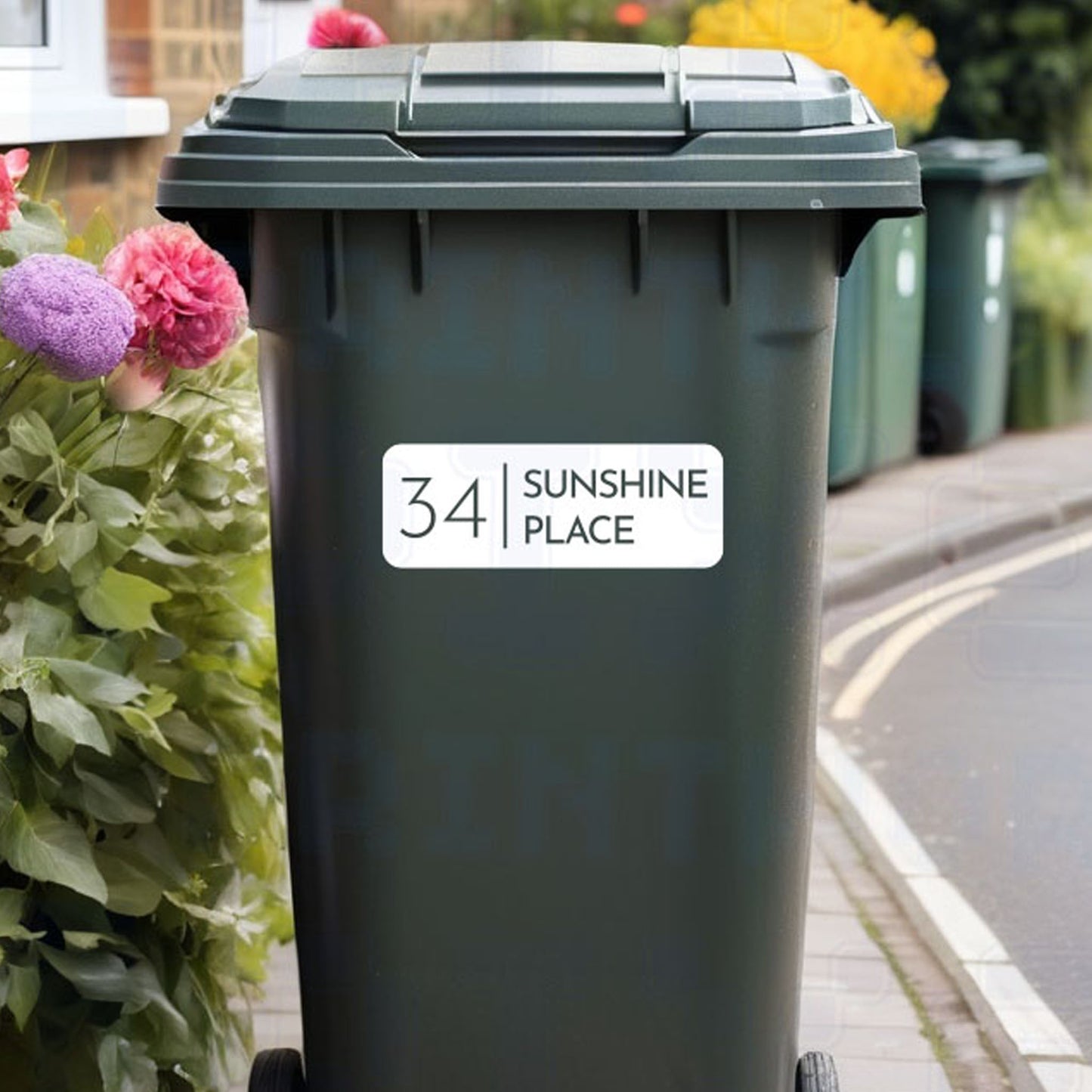 Personalised inverted classic wheelie bin sticker showing bold number and street name inside an outlined box on a bin outside a UK home by Pixel Printworks