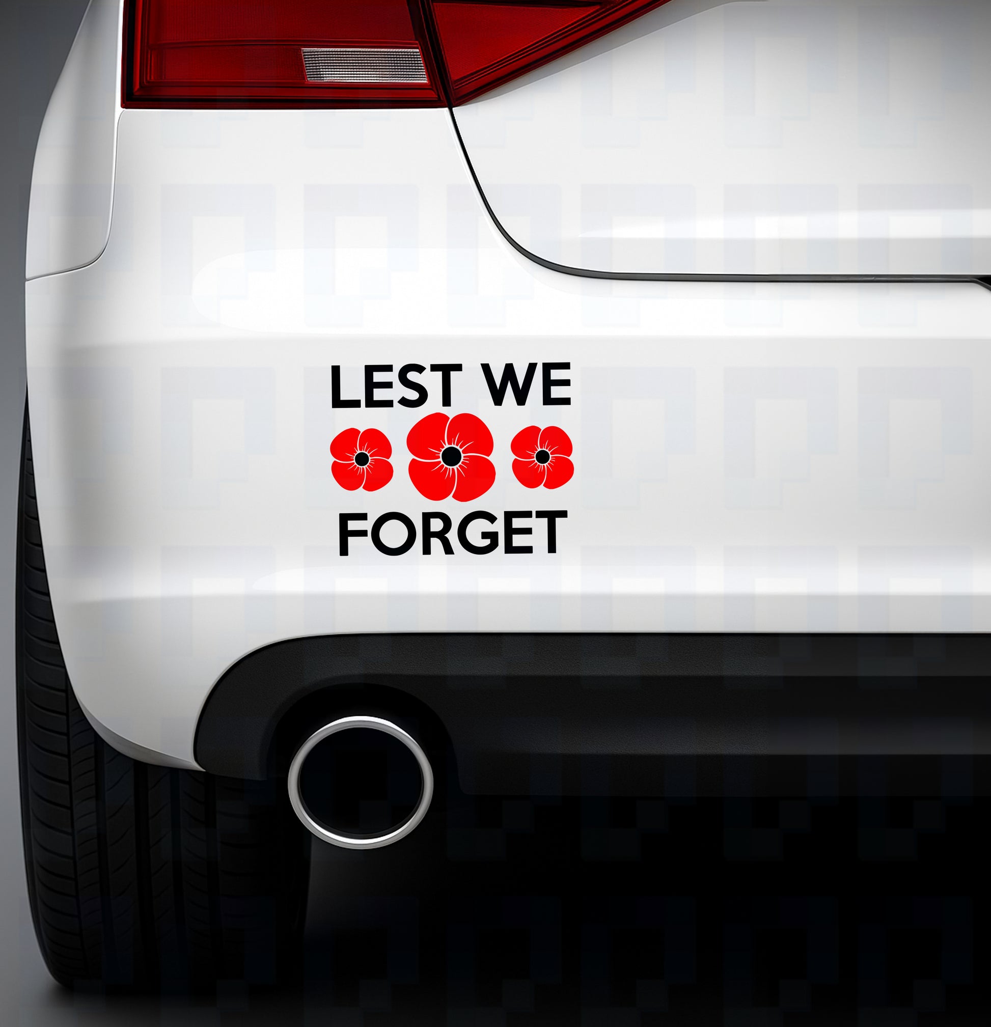 Lest We Forget bumper sticker with three red poppies replacing the “O”, applied to the rear of a white car
